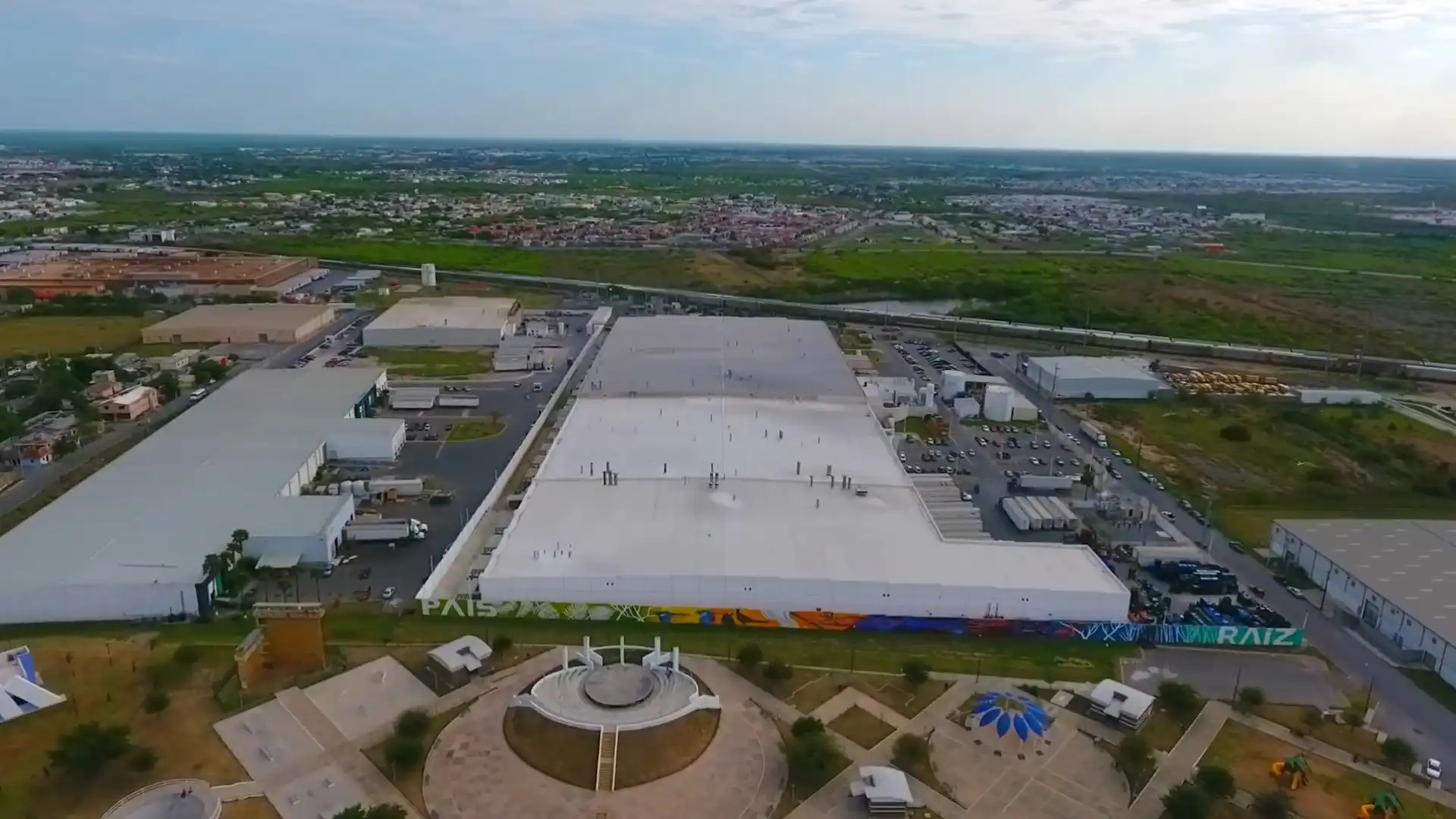 Vista aérea del Parque Industrial en Nuevo Laredo, con naves industriales y áreas de carga y descarga.